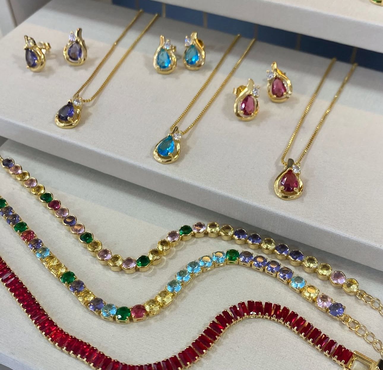 Vitrine com conjuntos de joias coloridas